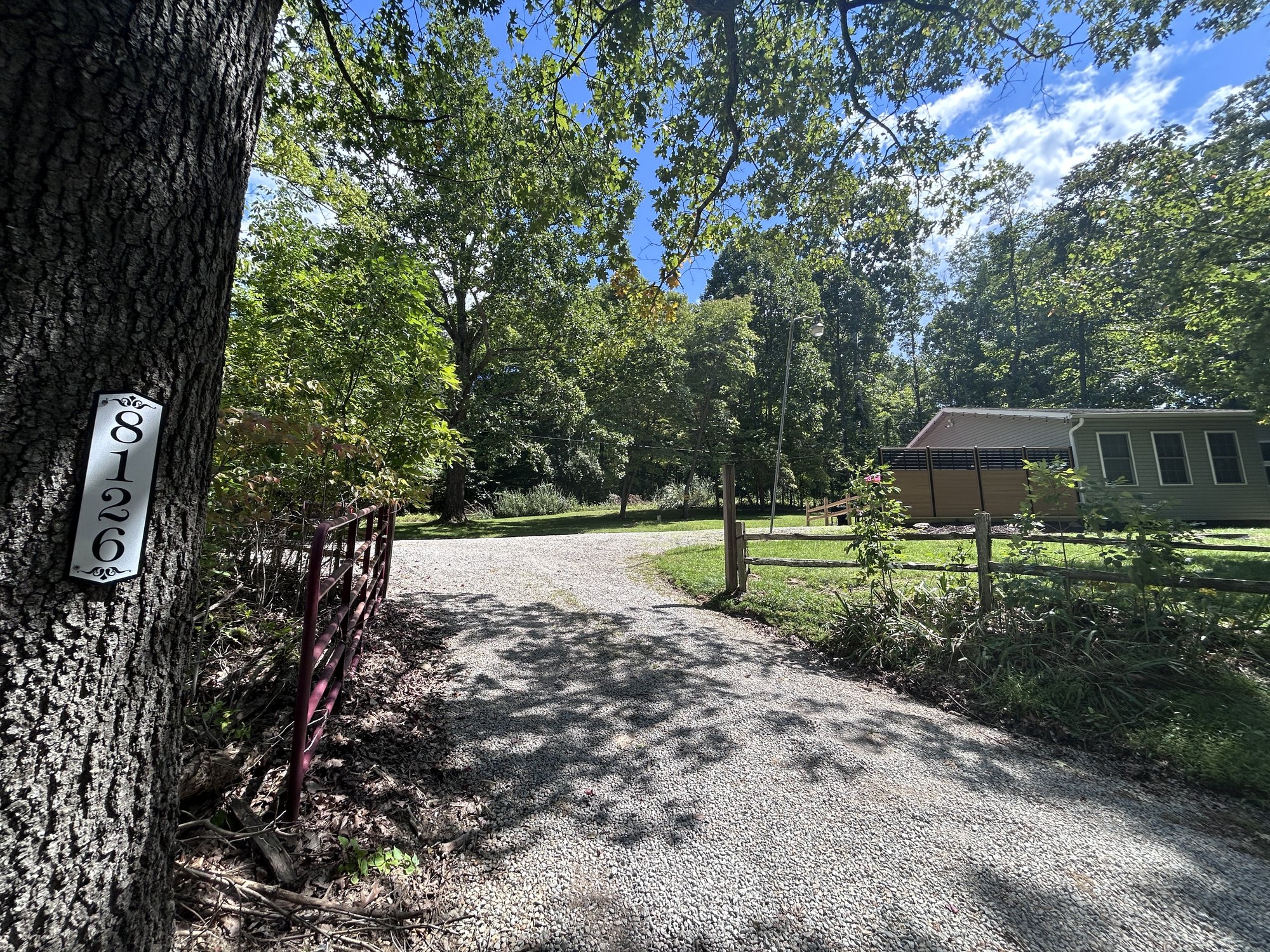 The gravel drive in to Old Beech Cottage, with the house number mounted on a roadside tree